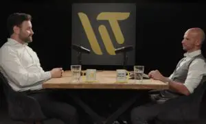 Podcast-Interview über Betrugsprävention im Unternehmen und Leadership-Strategien. Zwei Business-Experten am Studiotisch mit Mikrofonen und dem WT-Logo im Hintergrund.